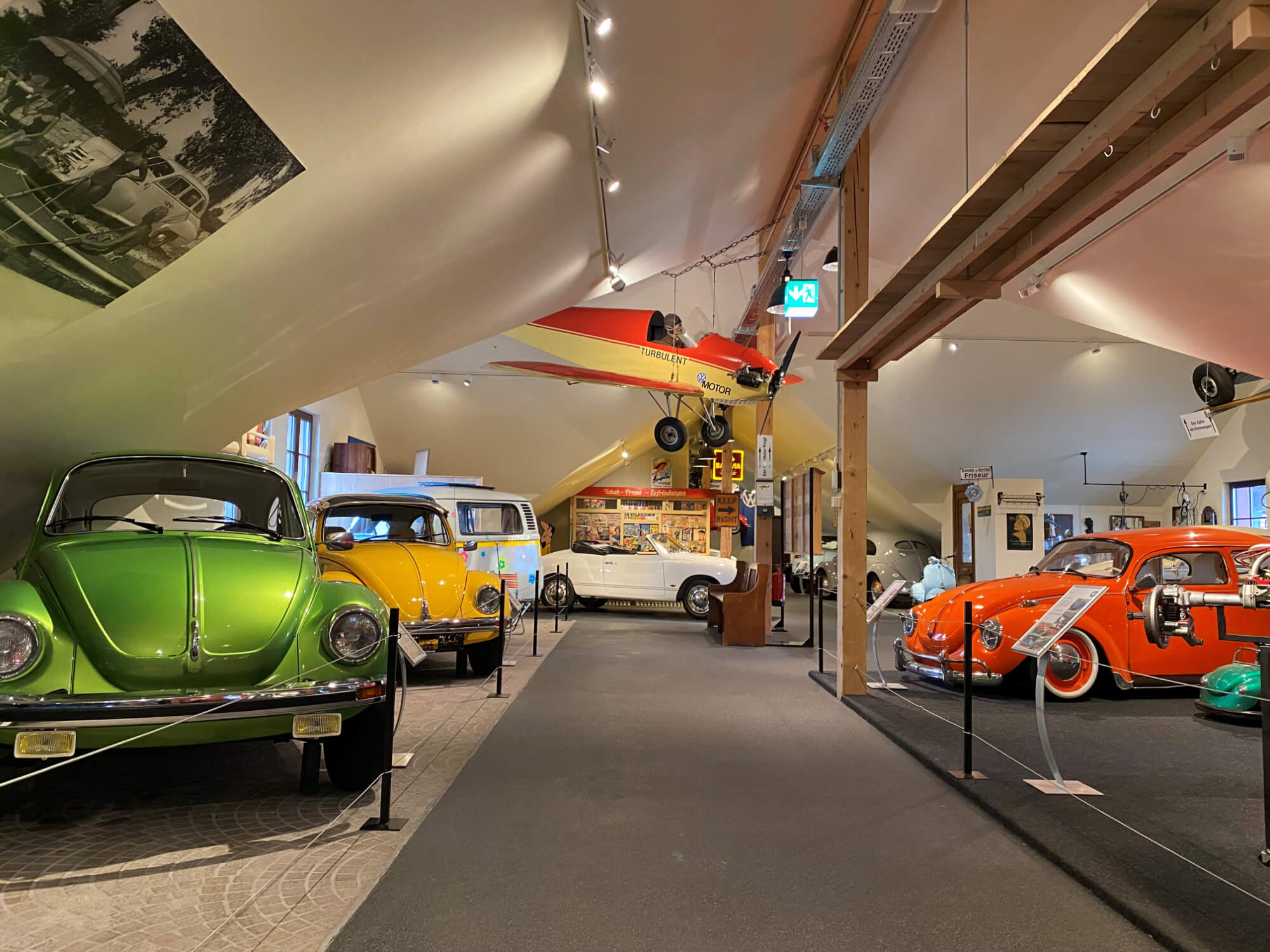 Das Dachgeschoss vom Museum, Verschiedene VW Käfer werden präsentiert. An der Decke hängt ein Flugzeug.